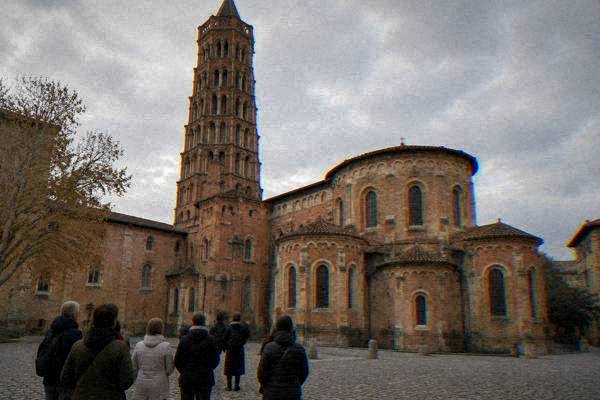 A small group following a guide through a brick street in the old town