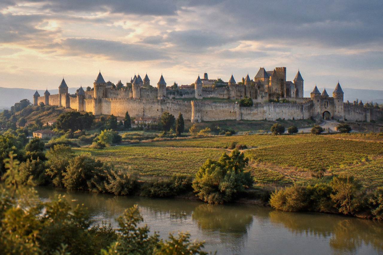 The double ring of fortified walls and pointed towers of the medieval city of Carcassonne seen at dusk