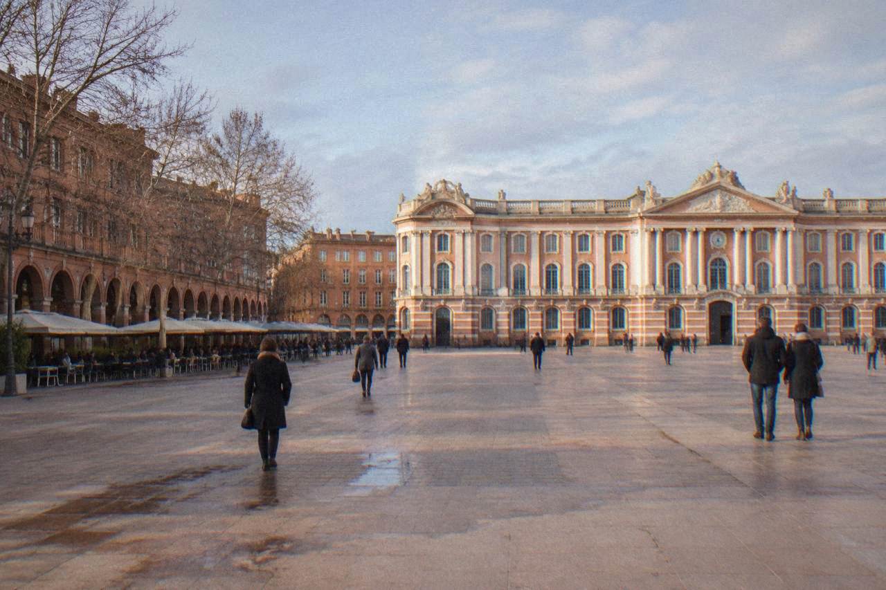 Toulouse's Capitole building and square in winter, with pink brick facades under a pale December sky