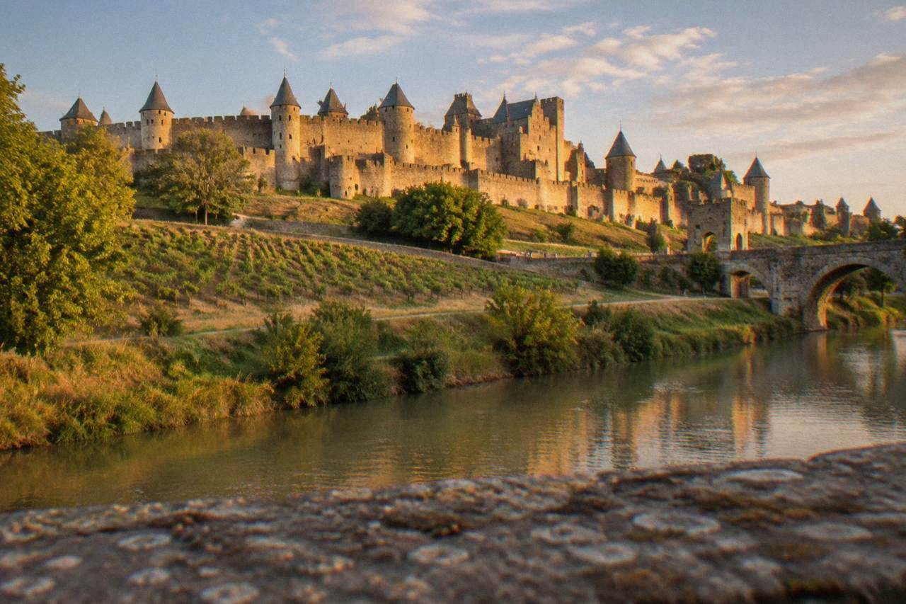 The double stone walls and conical towers of the medieval citadel of Carcassonne seen from below at golden hour
