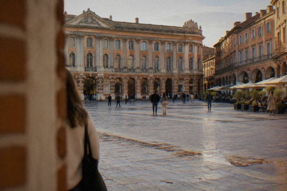 The wide open Place du Capitole in Toulouse with cafe terraces under the arcades