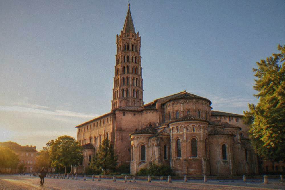 The interior nave of the Basilique Saint-Sernin with stone columns and warm light