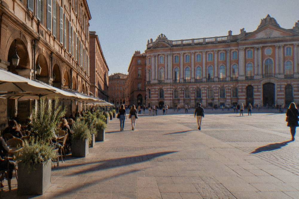 A quiet Toulouse street with terracotta brick facades and shuttered windows