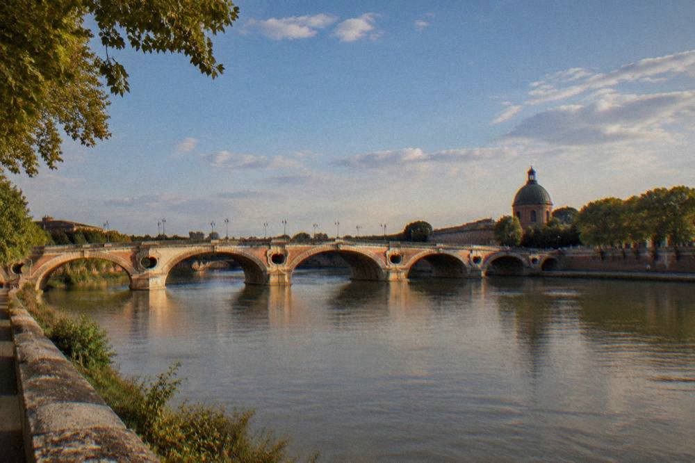 The Garonne river and the Pont Neuf seen from the banks near the basilica quarter