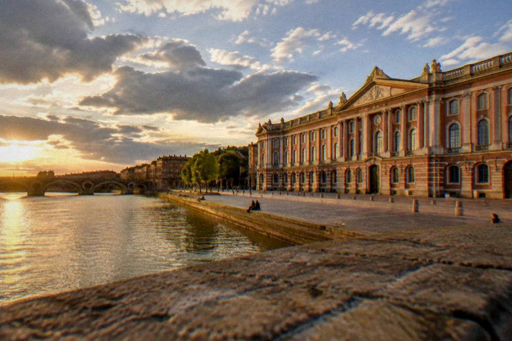 A view along the Garonne river toward the Pont Neuf bridge at golden hour