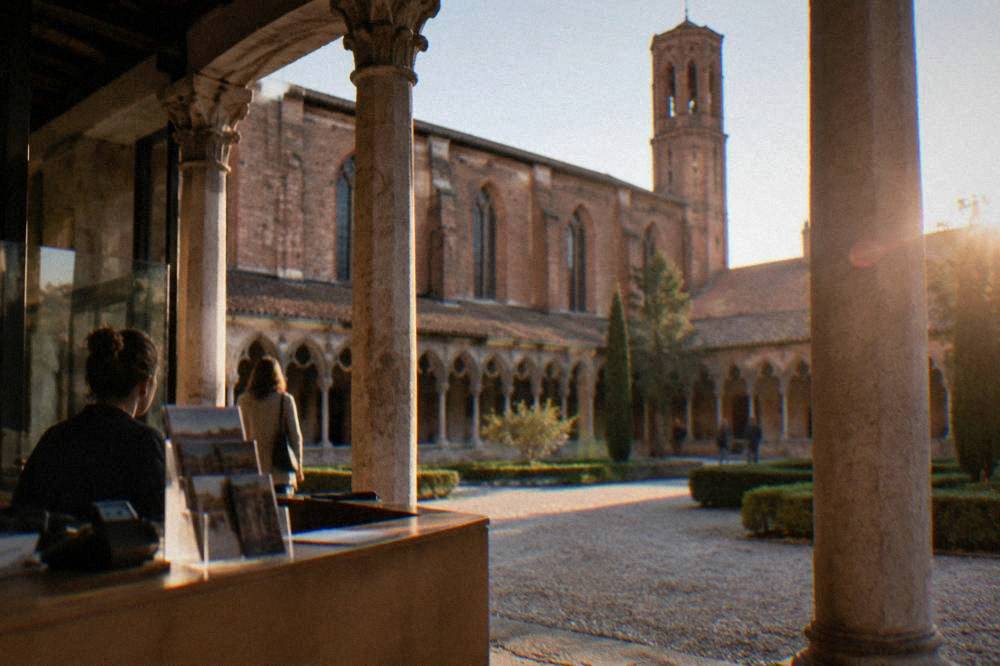 Ticket desk and information signage inside a historic brick convent entrance hall