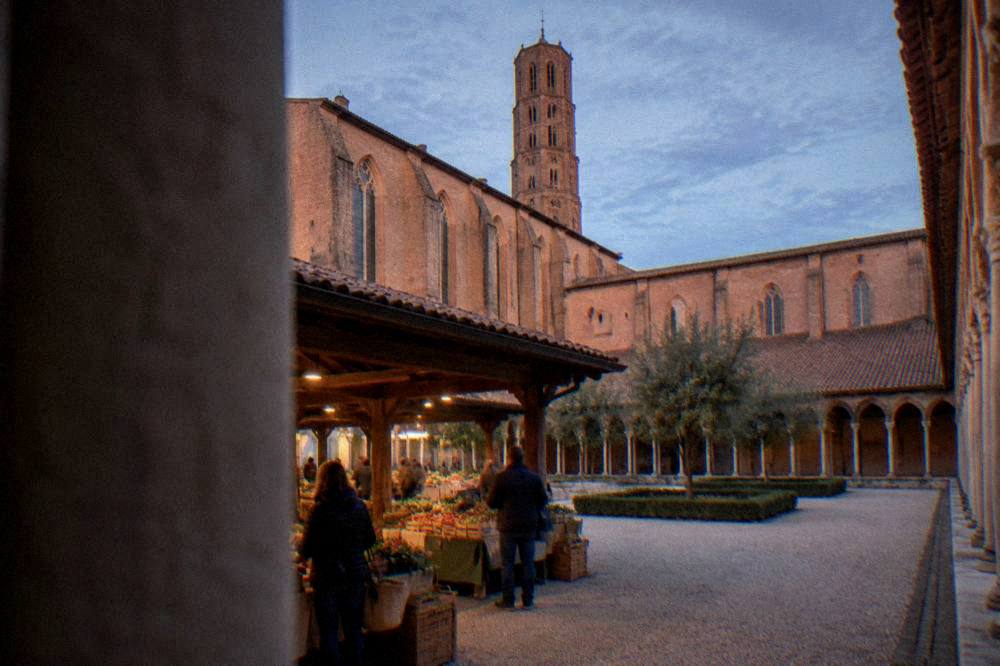 Outdoor market stalls with regional produce under a covered hall