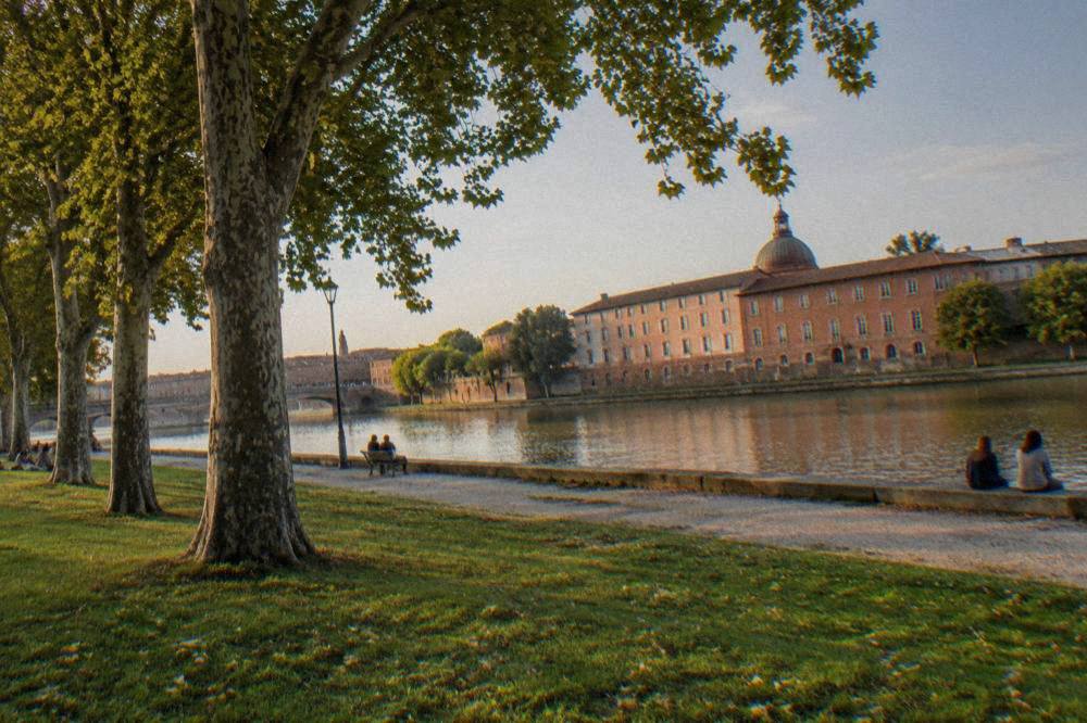 The chapel dome of the Hopital de La Grave rising over pink brick buildings beside the Garonne in Toulouse