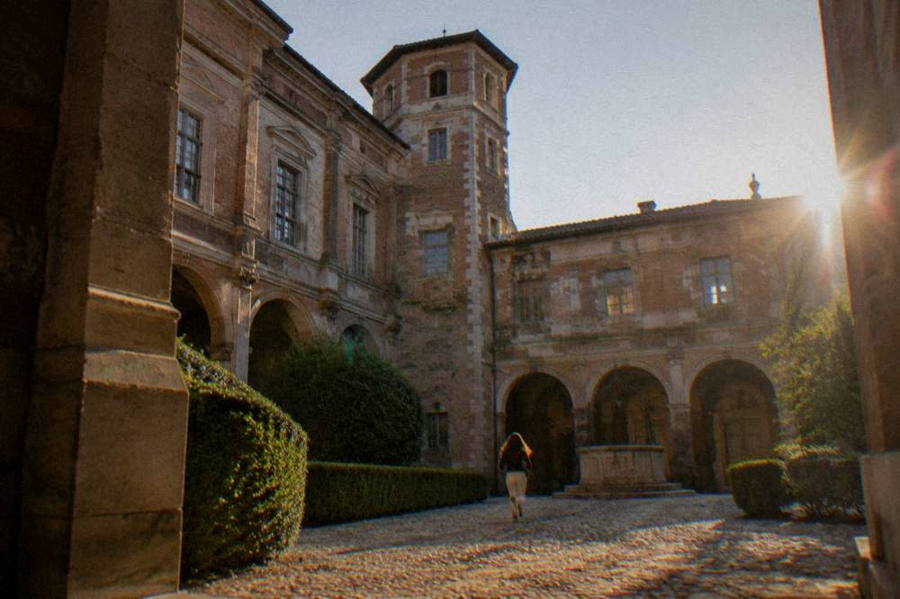 The stone and brick courtyard of the Hotel d'Assezat seen from below, with its tower and arches