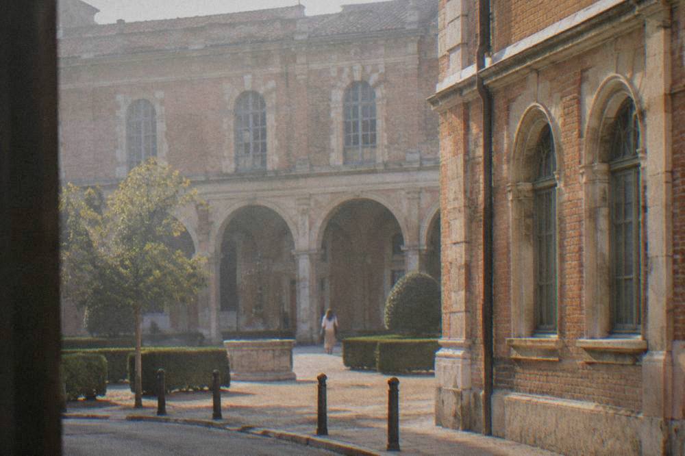 A pink brick mansion facade with arched windows on a Toulouse street near the Hotel d'Assezat