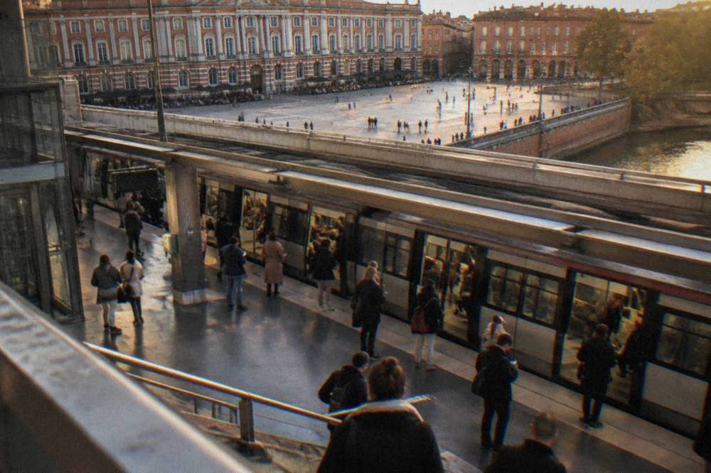 A Toulouse metro station platform with a modern train and passengers waiting