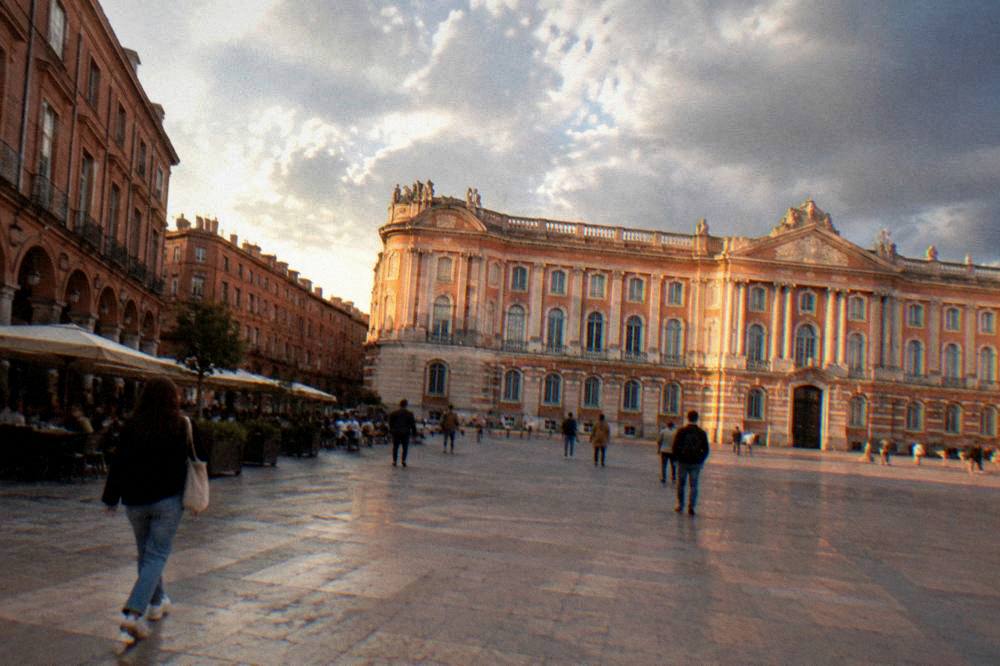The pink-brick facade of a Toulouse mansion glowing in warm late afternoon sunlight