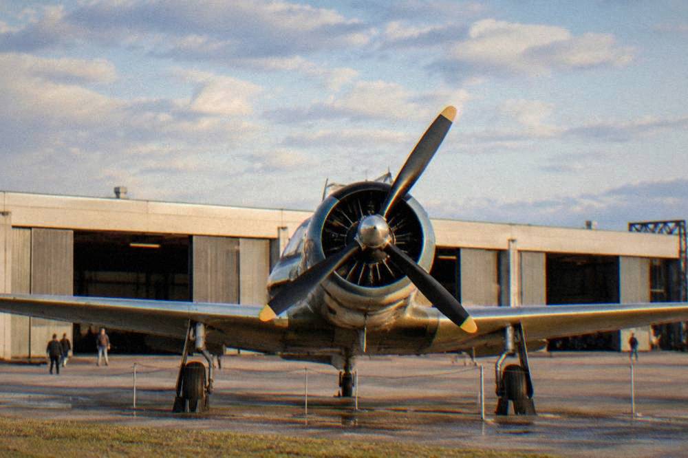 A vintage propeller aircraft nose and radial engine shown from the front in an aviation museum