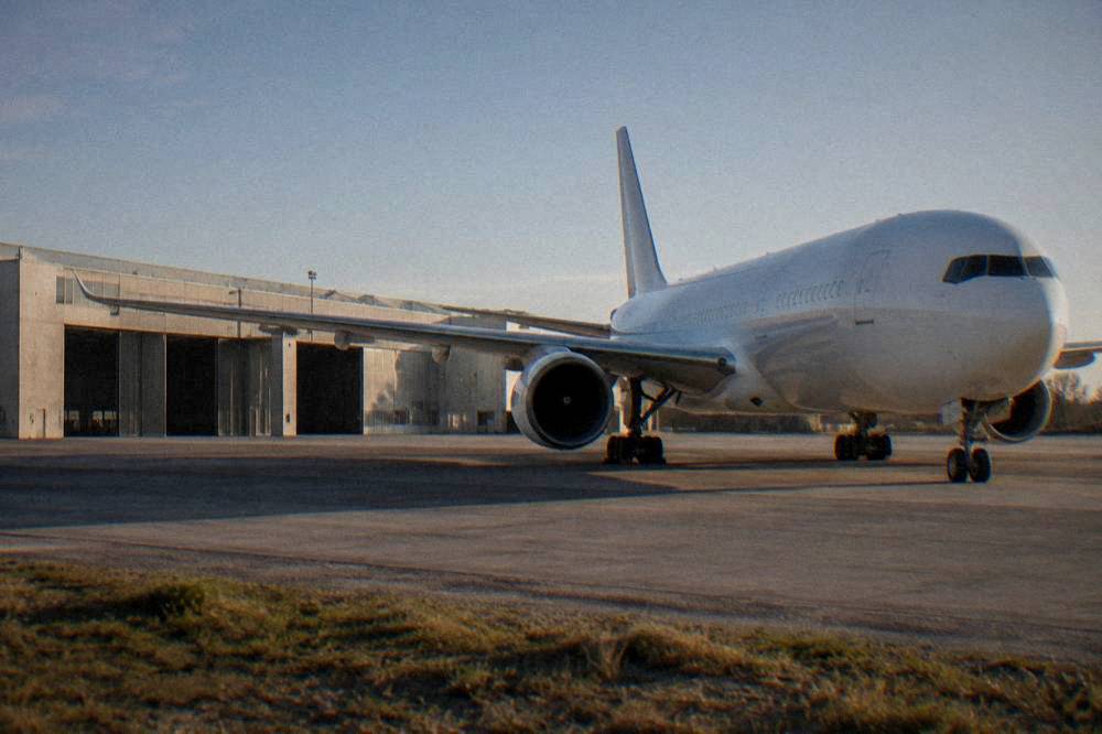 A modern wide-body airliner parked outdoors on a tarmac under a clear sky