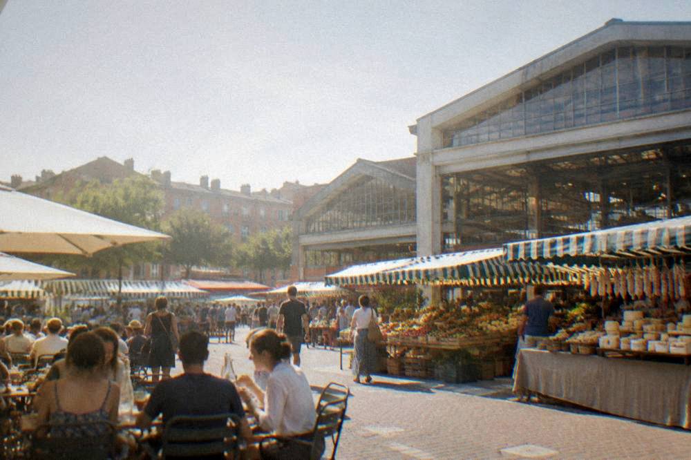 A busy lunchtime table beside a covered market in a southern French city