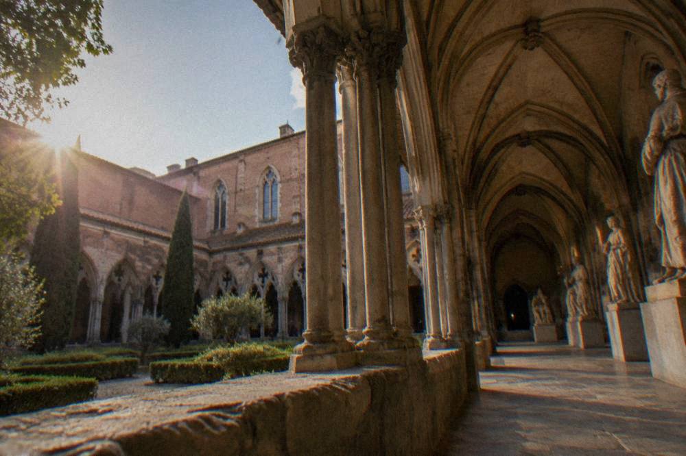 A Gothic stone hall with sculptures displayed under vaulted ceilings