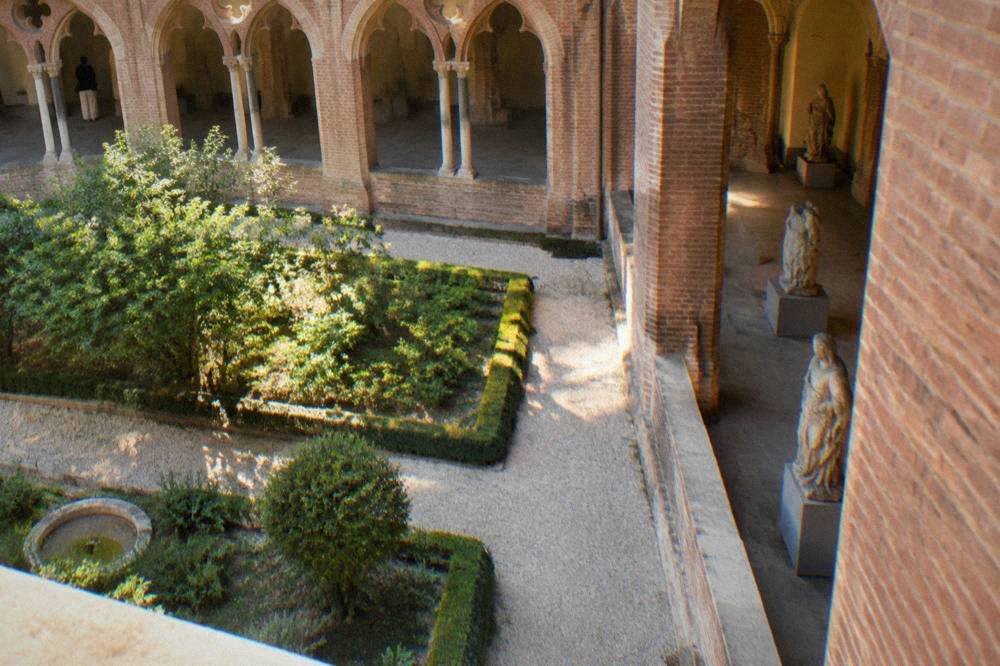 Medieval stone sculptures displayed on pedestals in a gallery