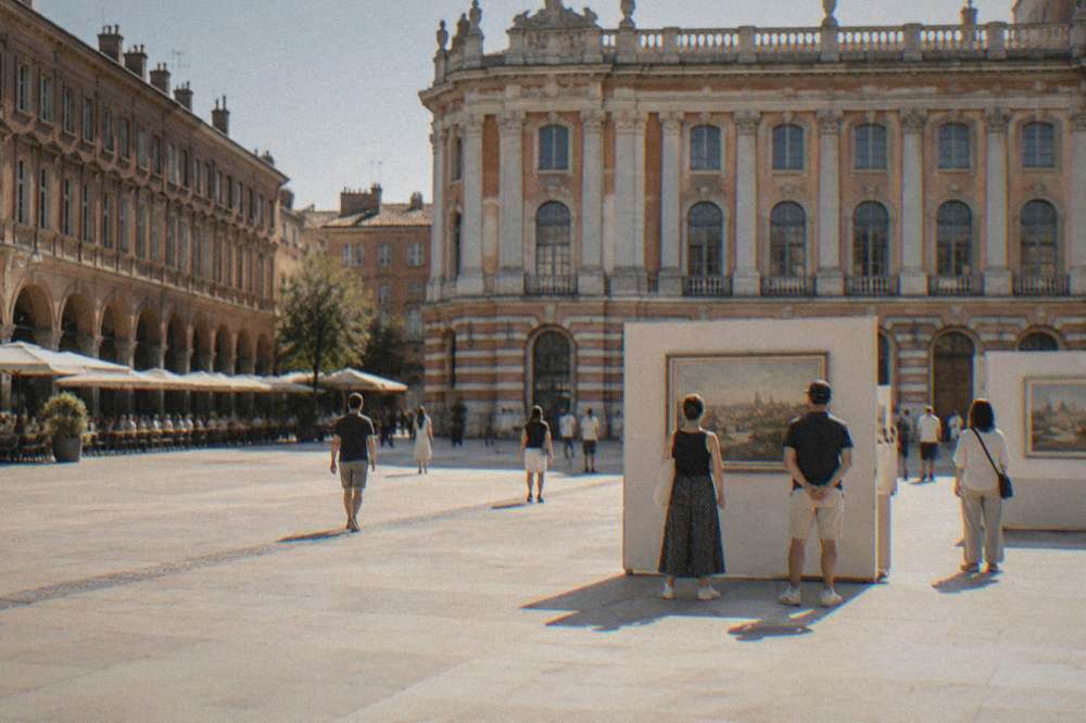 Visitors looking at paintings in a bright museum gallery in Toulouse