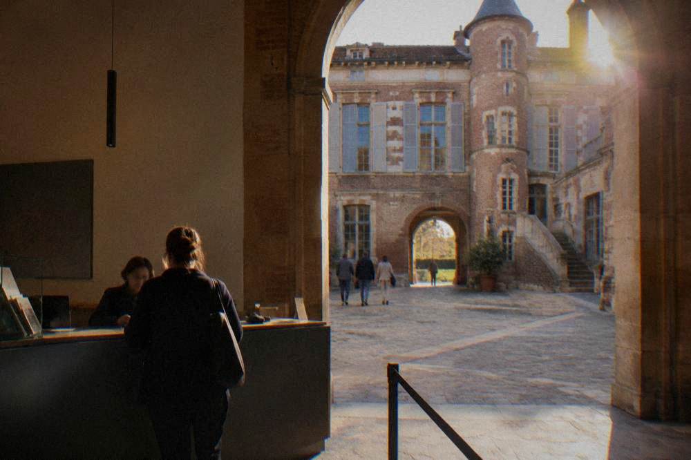 A ticket desk in a museum lobby with a visitor buying an admission ticket