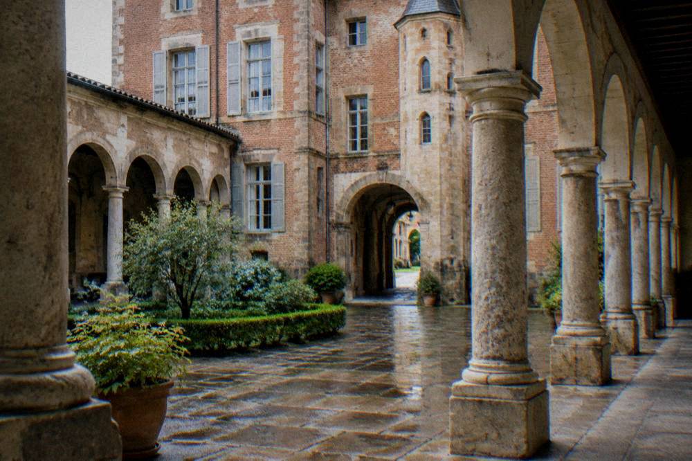 A stone cloister with columns and arches surrounding an open courtyard