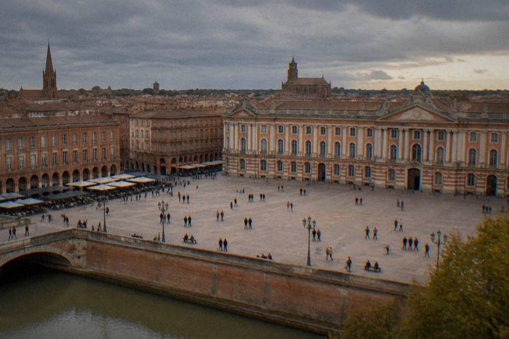 Rain clouds over Toulouse rooftops with church spires in the distance