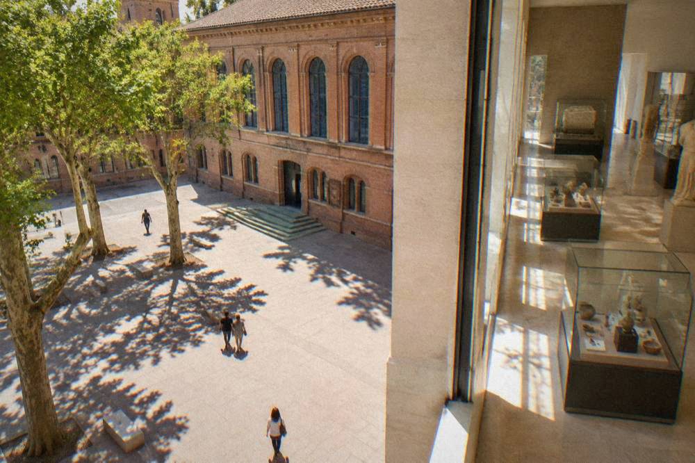 A bright renovated gallery interior with glass display cases and pale stone walls