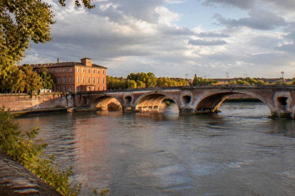 The facade of a pink brick building near the Pont Neuf in Toulouse
