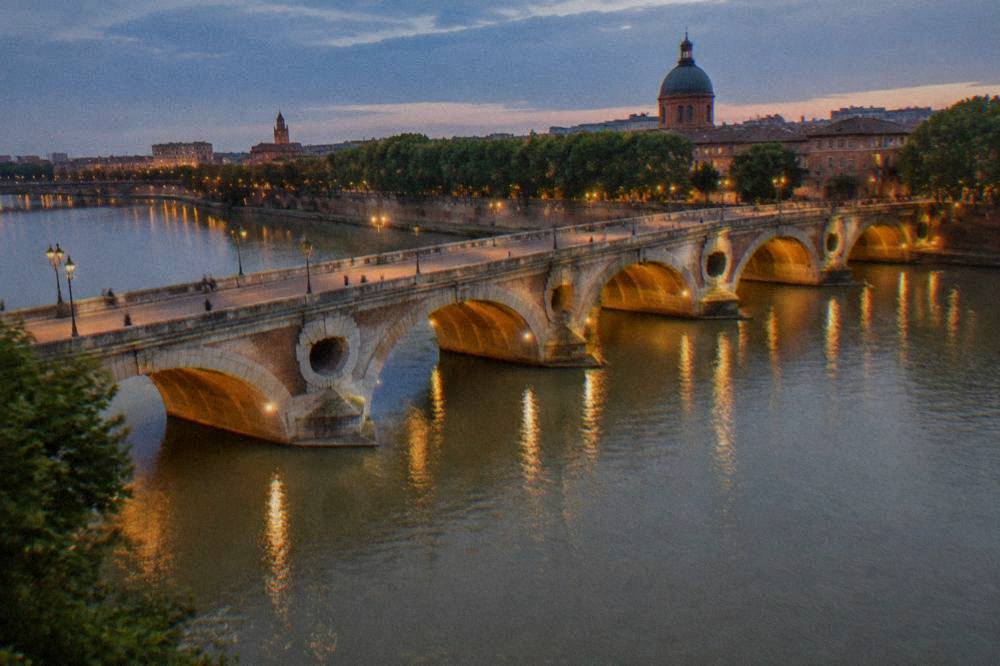 Evening lights reflecting on the Garonne under the arches of the Pont Neuf