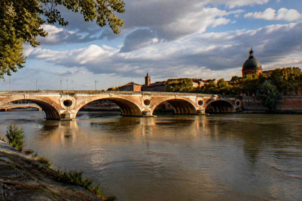 Wide view of the Pont Neuf and the Garonne riverfront in Toulouse