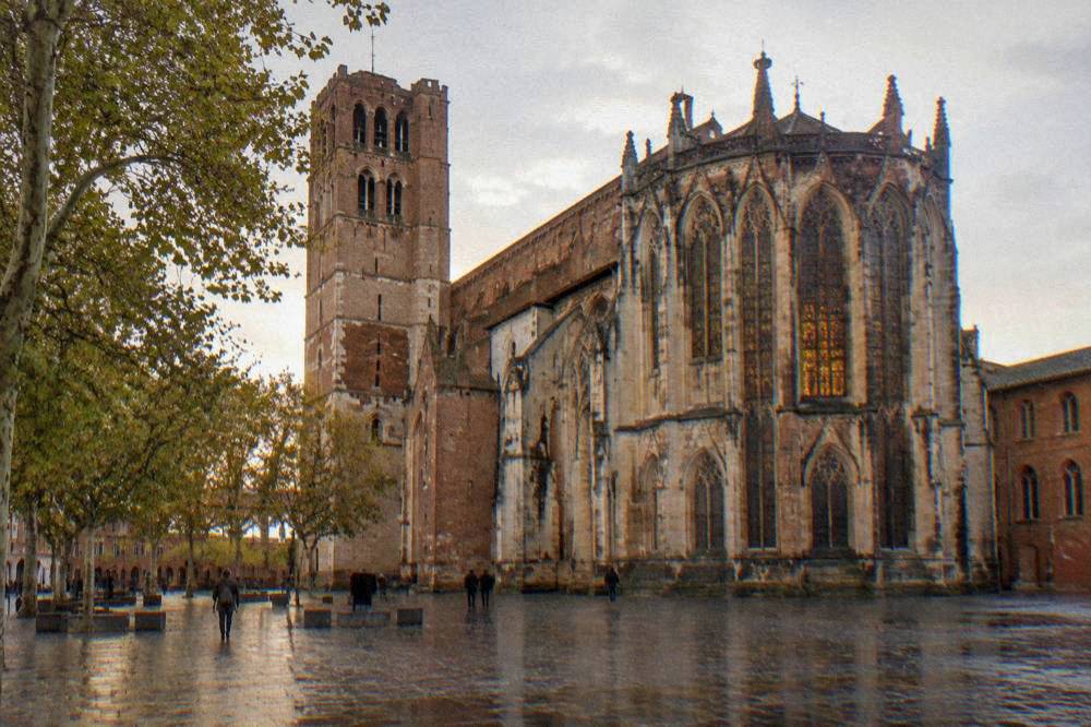 The tall choir of Toulouse Cathedral with its stained glass windows lit from outside