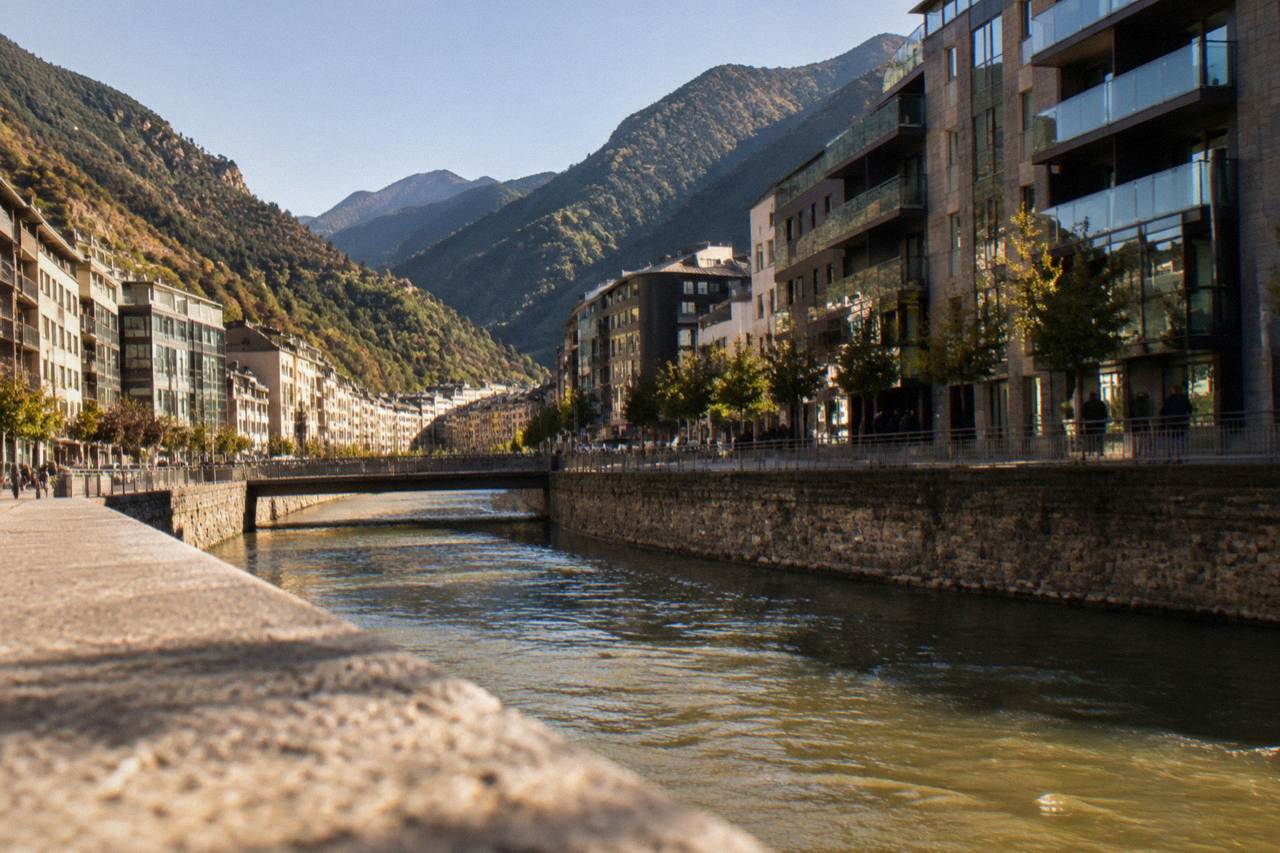 A winding mountain road with forested peaks in the Pyrenees under a clear sky