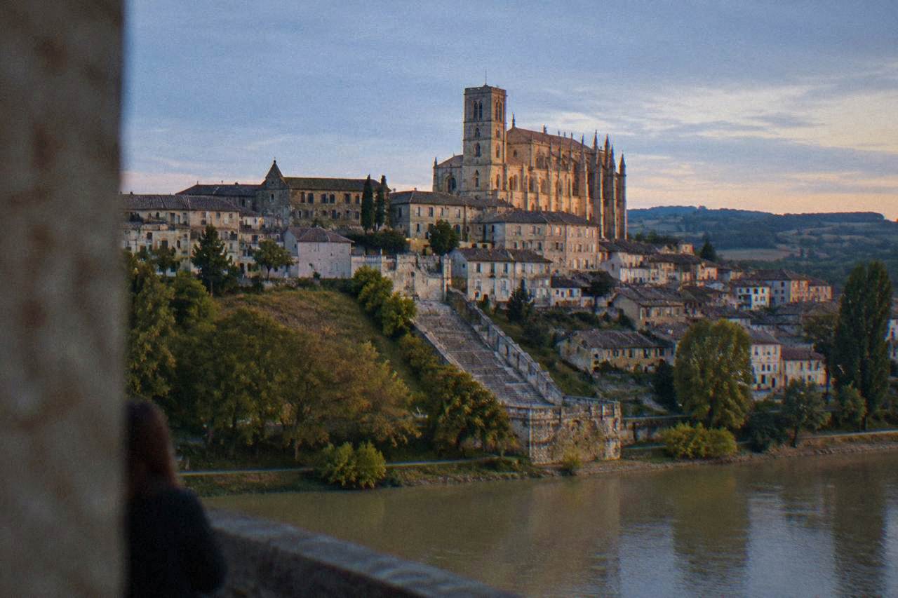 The old town of Auch seen from below, with its cathedral rising above tiled rooftops