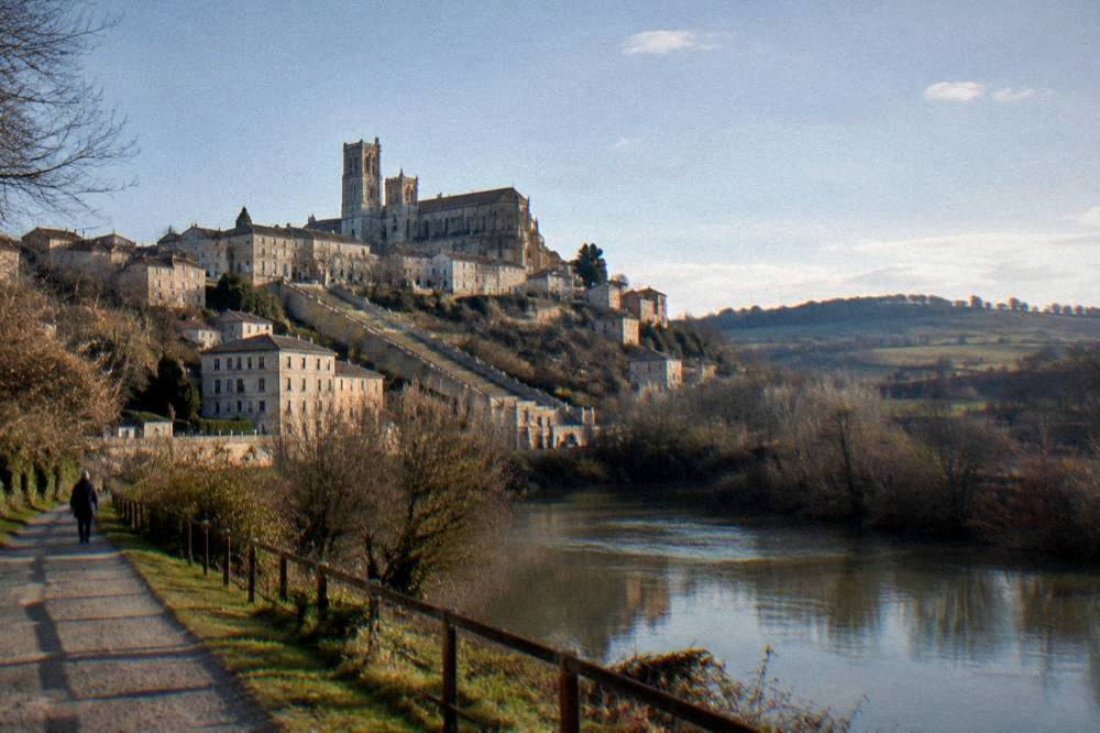 A riverside path below the old town with the hill of Auch in the background