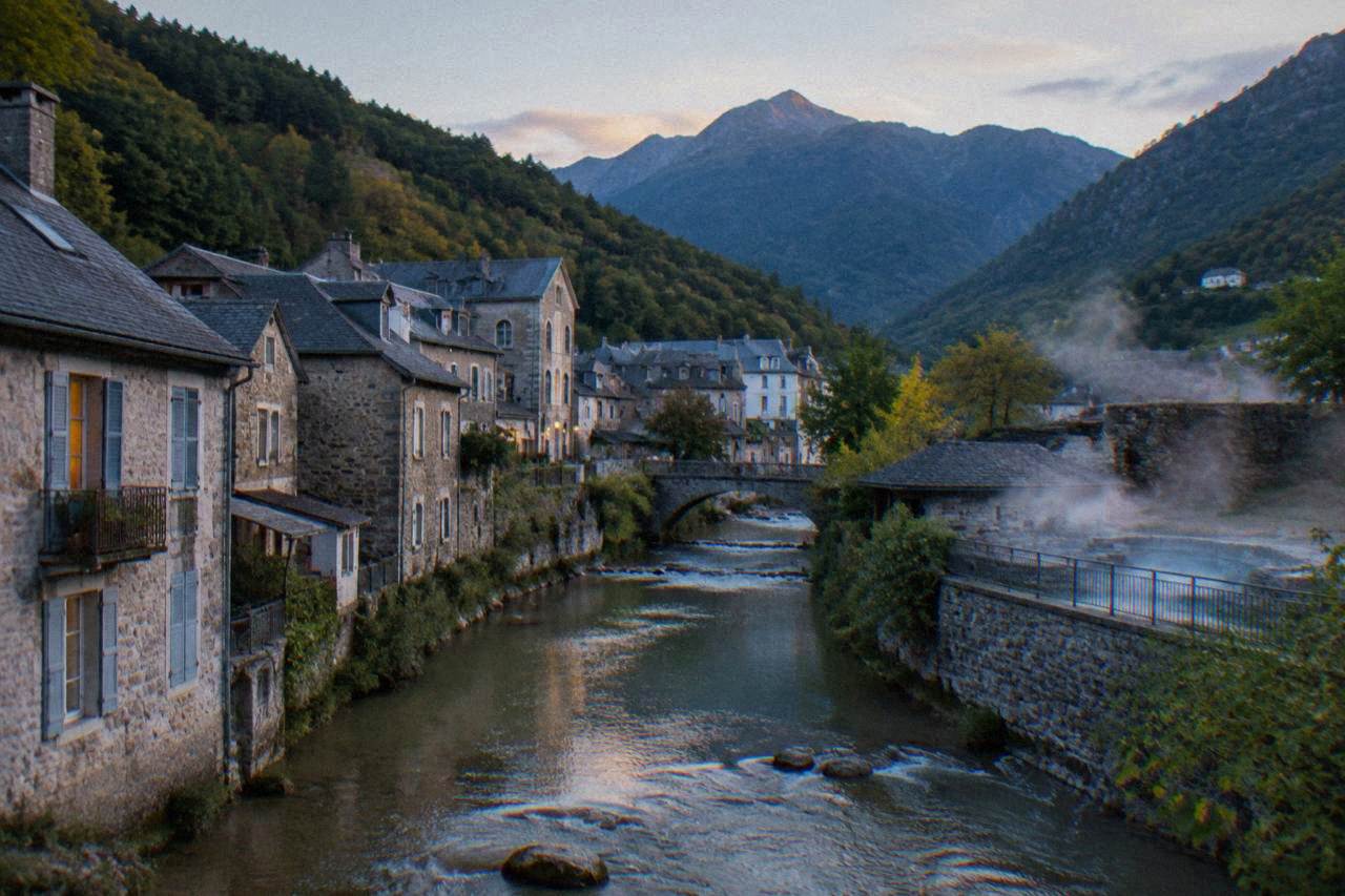A small Pyrenean spa town with mountain peaks rising behind rooftops