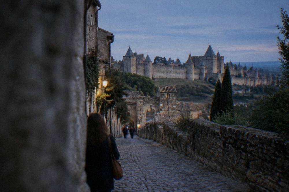 Narrow cobbled street inside a medieval walled town lined with stone buildings