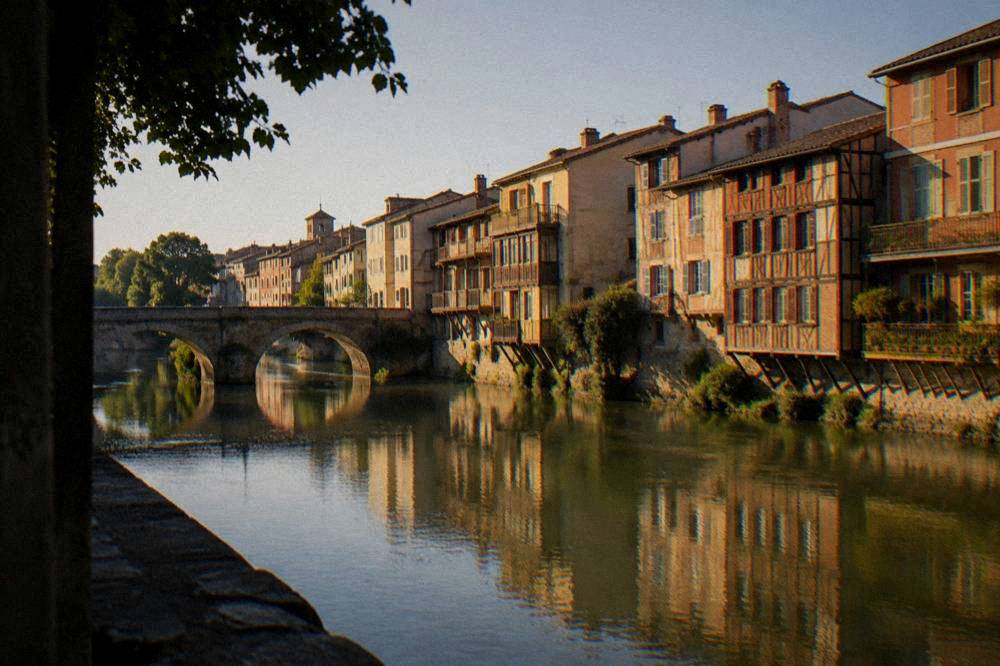 A riverside row of colorful timber houses in warm evening light
