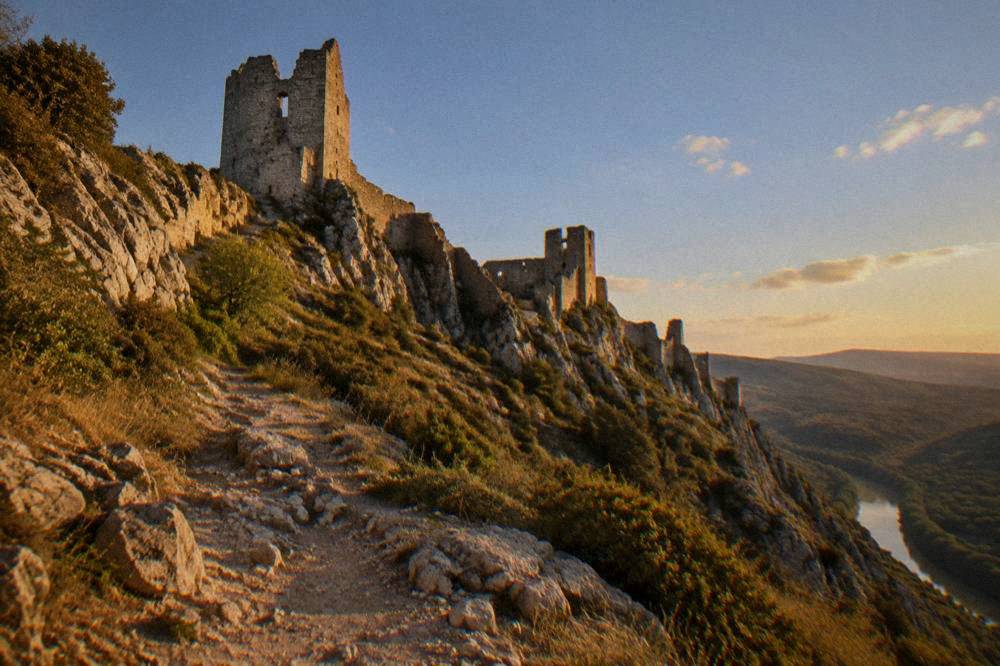 Towers and walls of a restored medieval walled city seen from below at golden hour