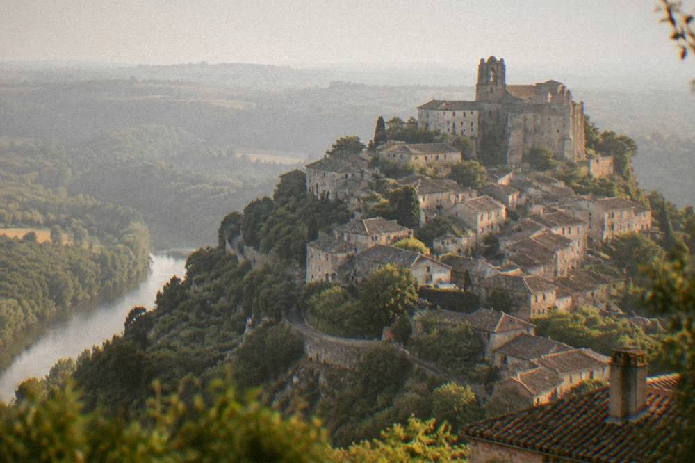 A hilltop village glowing in evening light above a river valley