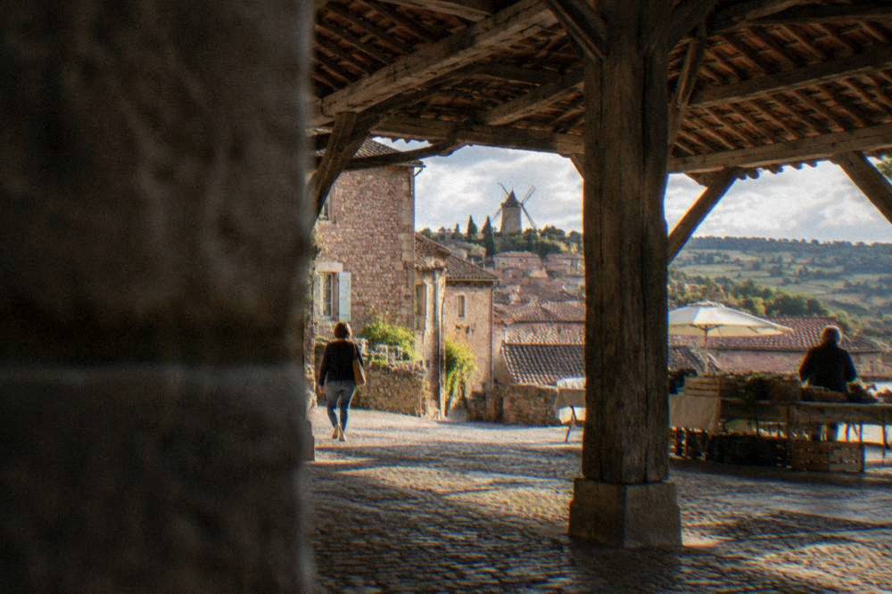 A medieval covered market hall with timber beams in a French village square
