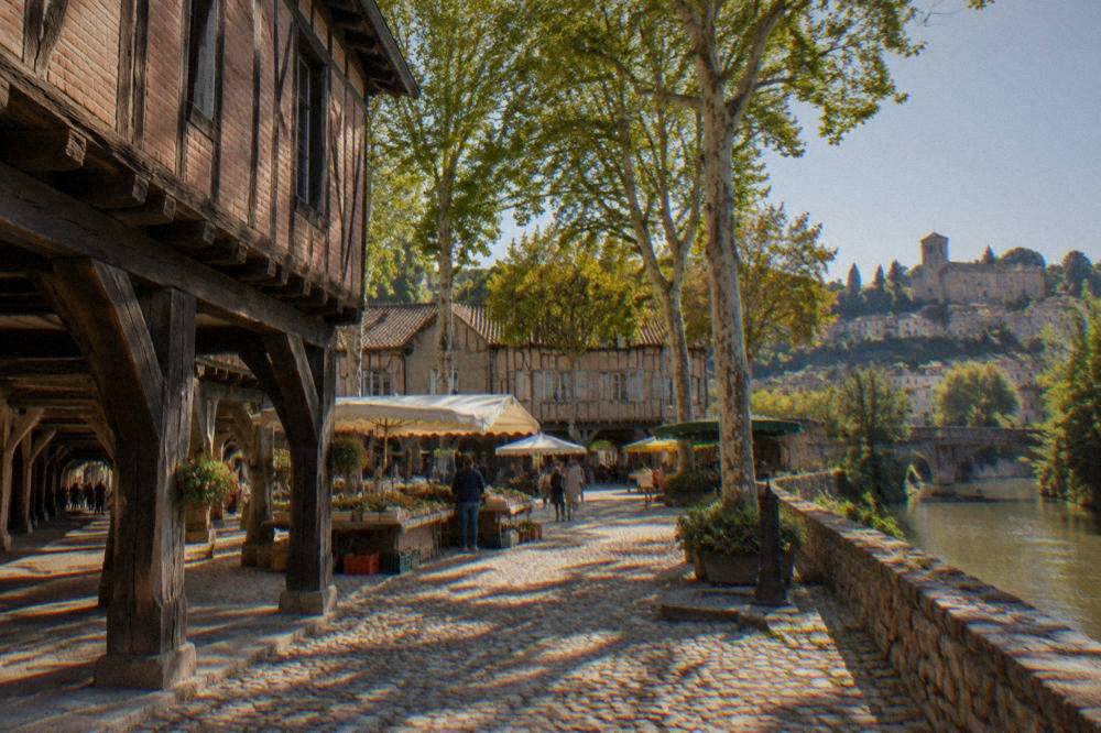 A hilltop village with stone houses rising in tiers above a river valley in southern France