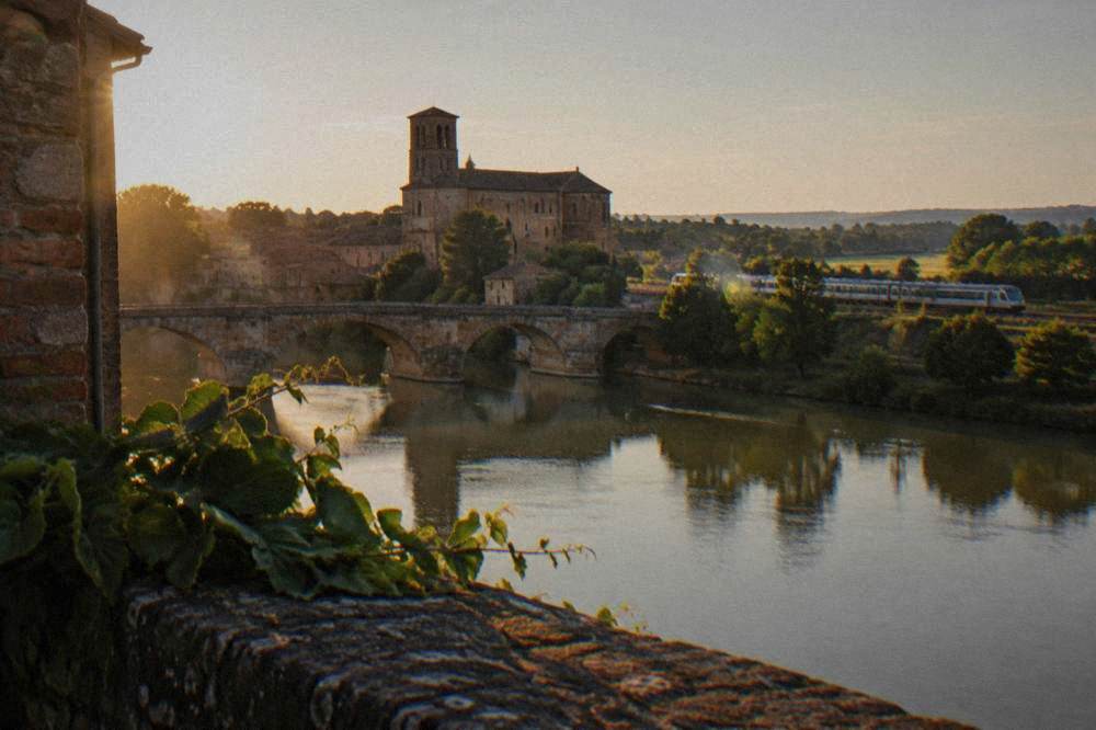 A regional train traveling through farmland along the Garonne valley in southwestern France