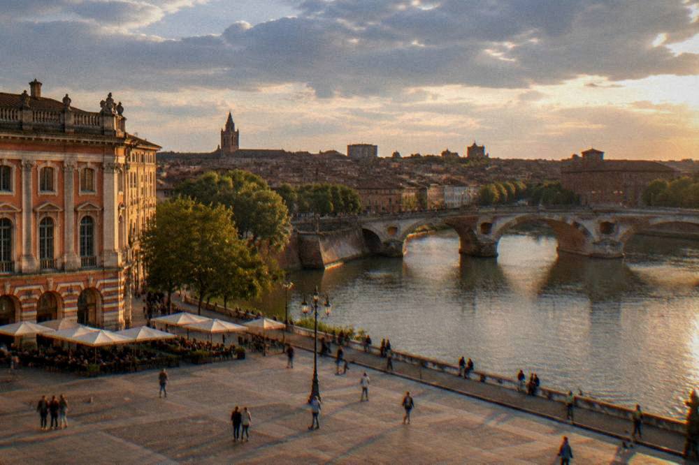 Evening light on the Garonne river in Toulouse with the city's rooftops behind