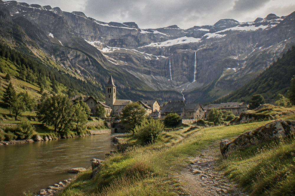 A mountain village with stone houses and a church tower nestled in a green Pyrenees valley