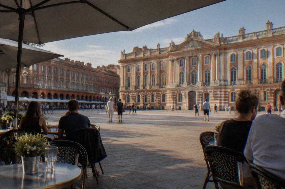 A shaded cafe terrace on a Toulouse square on a sunny warm day