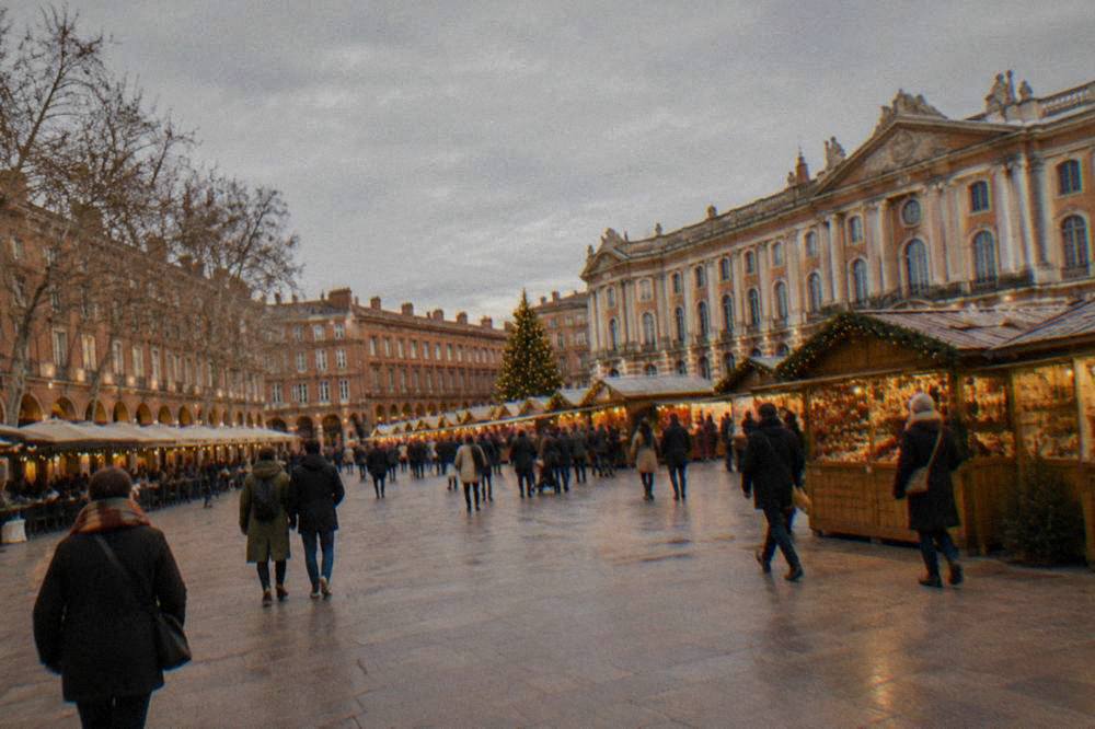A Toulouse Christmas market with wooden chalets and festive lights on a square