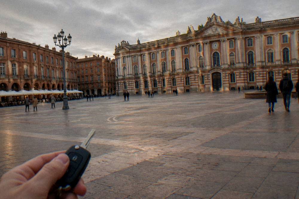 A hire car key with a Toulouse city map on the dashboard at sunset