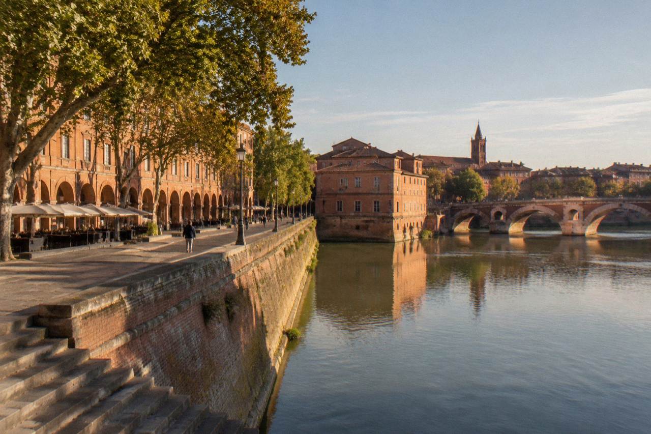 Pink brick buildings and a quiet street in central Toulouse in daylight