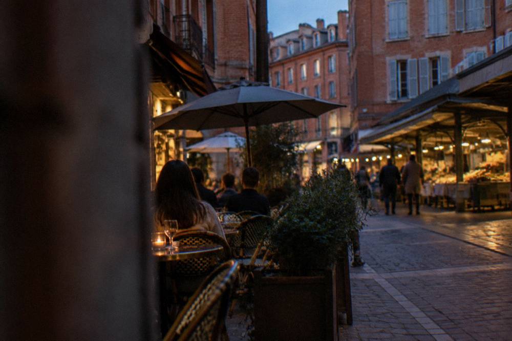 A café terrace on a narrow street in the Carmes district of Toulouse in the evening
