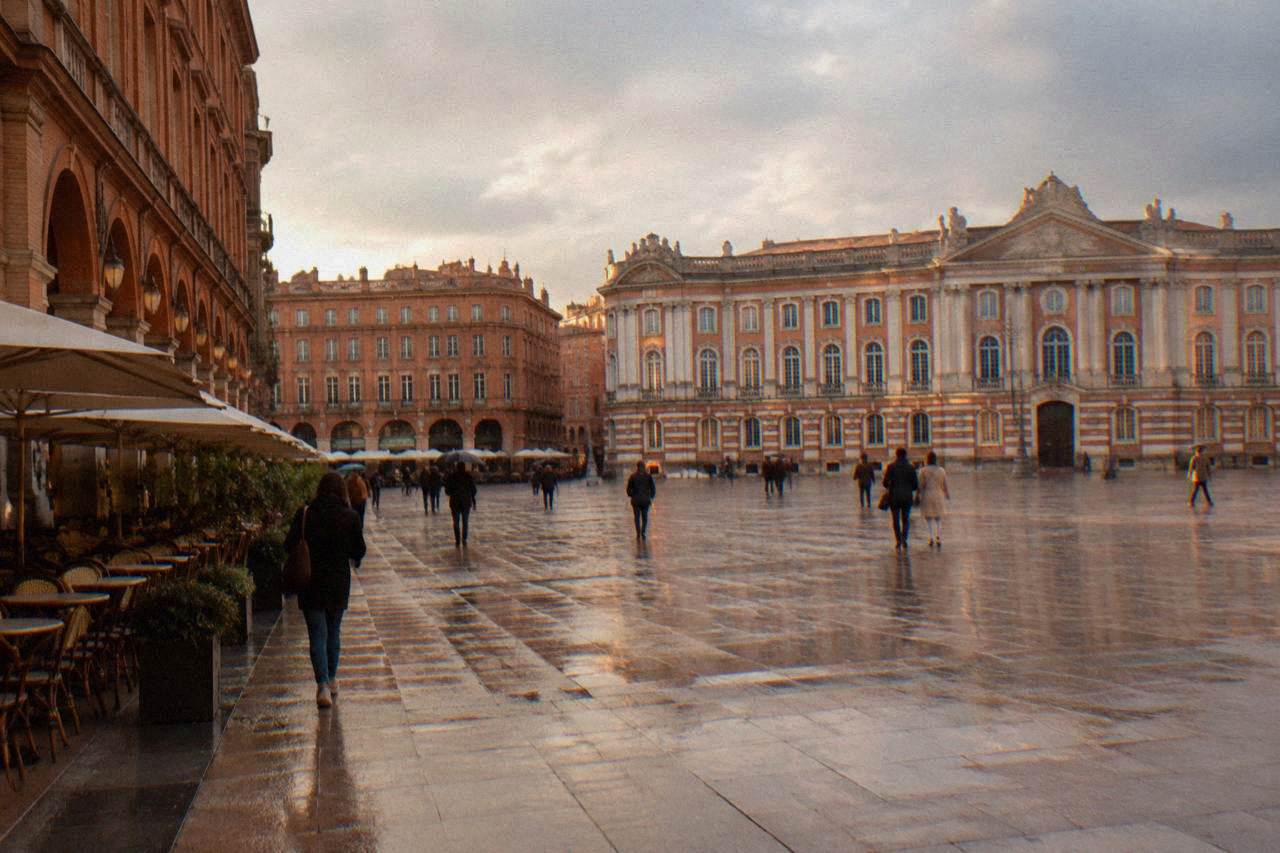 Pink brick buildings along a Toulouse street with the Capitole in the background