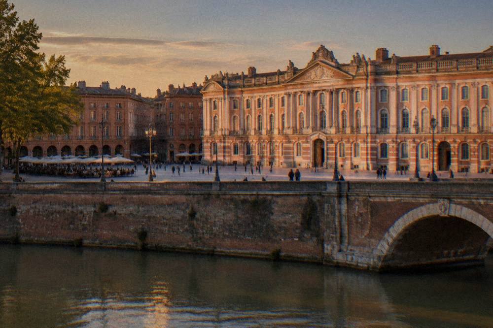 The Place du Capitole facade in pink brick at dusk